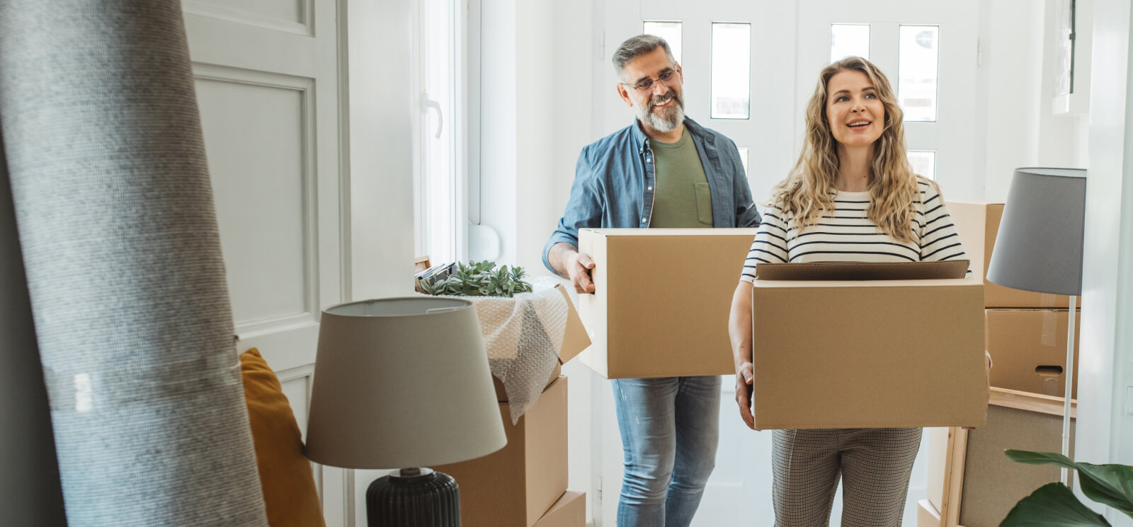 Middle aged couple moving in boxes to new home